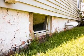 Outside the Wall Township home, a large crack was visible through the brick foundation wall, with loose sections of brick surrounding areas of the damaged masonry.