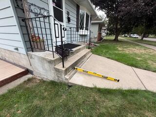 The walkway where the slabs have settled in front of the steps