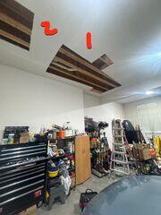 Before: Wide view of the garage ceiling showing the large open sections where drywall had been removed.