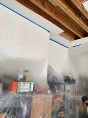 During: Protective plastic containment installed throughout the garage to help protect stored belongings and surrounding surfaces during the repair.