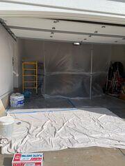 During: Plastic containment and floor protection were set up throughout the garage to help protect stored items and surrounding surfaces during the ceiling repair.