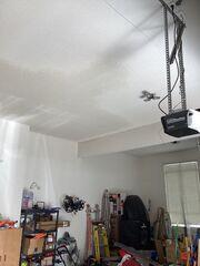 After: Wide view of the completed garage ceiling repair, with the patched areas blended into the existing popcorn texture and left ready for paint.