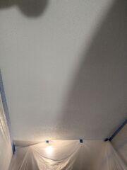 Popcorn texture being applied to the repaired garage ceiling area to blend the new drywall with the surrounding ceiling.