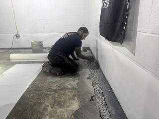 Foreman Anthoni installs WaterGuard along the basement perimeter as part of this waterproofing project. WaterGuard is an interior drainage system designed to collect groundwater entering along the foundation and direct it toward the sump pump for removal. Installing the system around the full perimeter helps provide comprehensive drainage coverage for the basement.