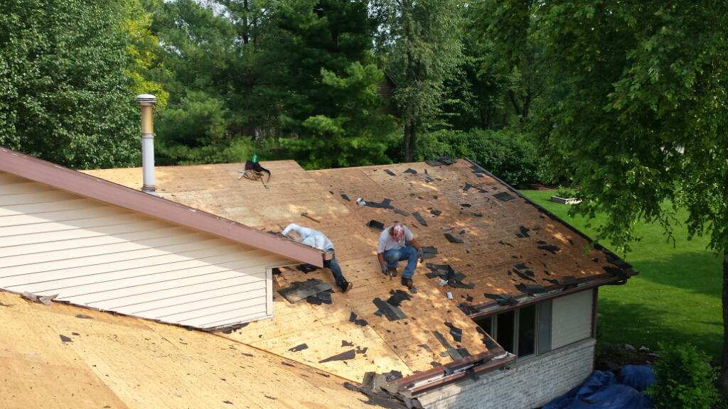 Tearing off 2 Layers of Roof Shingles Old roof is torn off just doing