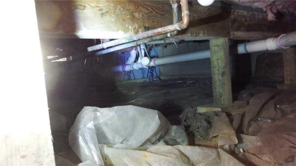 Encapsulating a Wet Crawl Space in Traverse City, MI Ineffective Plastic Sheeting in Crawl Space