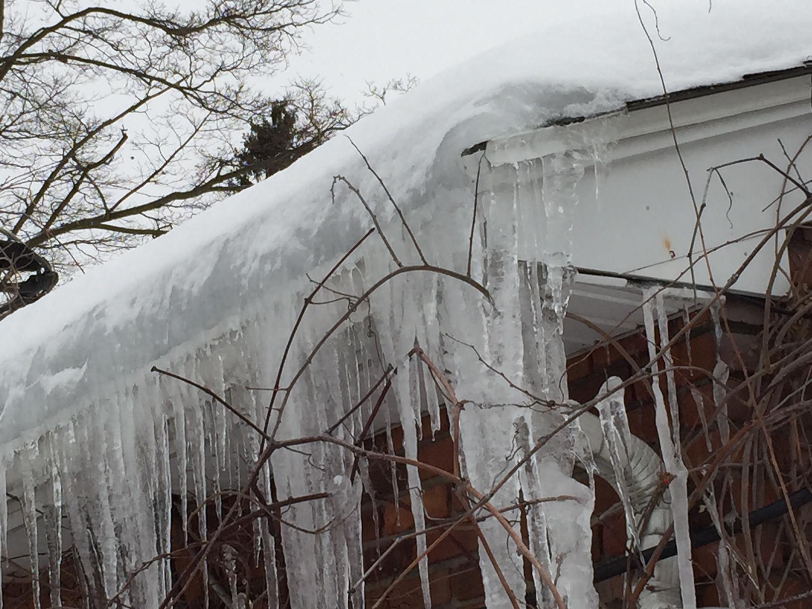 Frozen Gutters & Ice Dams Thick icicles on roof