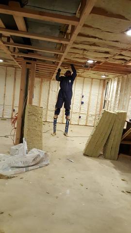 Use of stilts to install rock wool in the ceiling of the basement for sound deadening purposes.