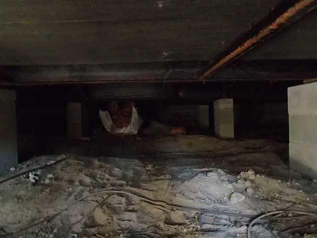 The crawl space is filled with dirt and debris.