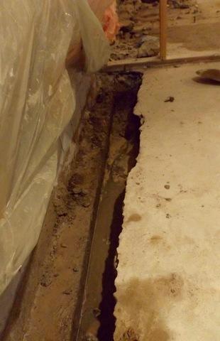 The crew worked to remove cement around the perimeter of the basement in order to install the waterproofing system.