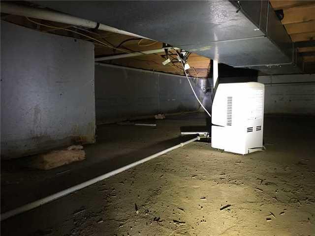 Between the water damage on the walls and the debris left behind, it's clear that water travels through this crawl space regularly.