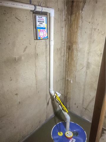 A view inside of the basement of the WaterGuard® below-floor drain system tying into the new SuperSump® sump pump system now cemented in place.