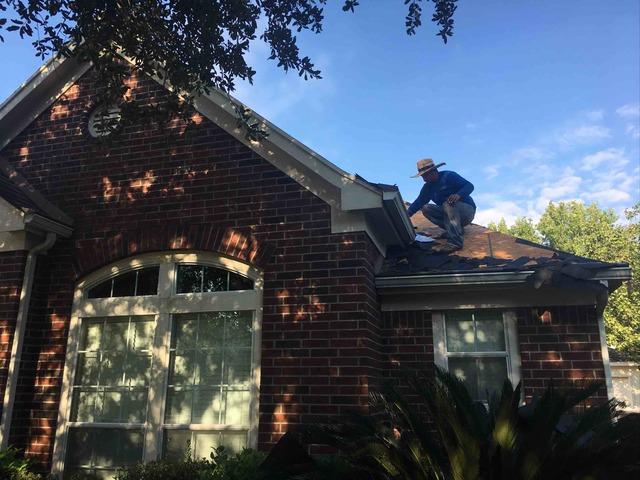 One of our great roof installers works on a tricky corner of the roof, ensuring all of the old roofing pieces are removed before the new material is installed.