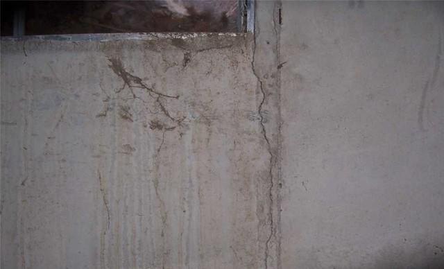 Wall cracks emanating from windows and doorways are very common when a home has bowing walls. The presence of water stains the cracks and makes them more visible, as seen here.