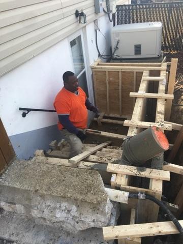 <p>Willie, our veteran foreman, pouring a new retaining wall for a stairwell entry</p>