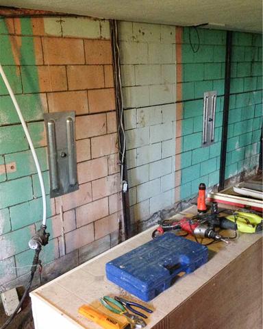 A view inside the basement of the home the where the Geo-Lock™ wall anchor system has been installed along portions of the bowing cinder-block foundation wall.