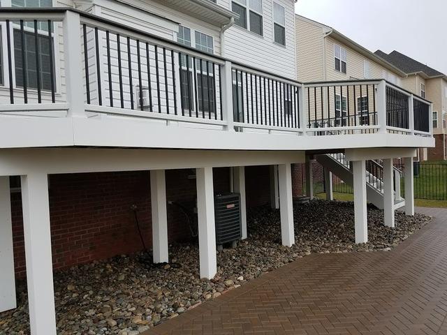 TREX Transchends deck installed in Ashburn, VA. Decking Color Island Mist. Railing-TREX Trandscends. Patio: Ep henry Dakota Blend Brick stone.