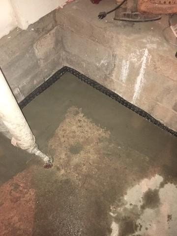 We use dimple drainage matting against the wall here to help lead water down the wall into the drain tile which leads to the sump pump.