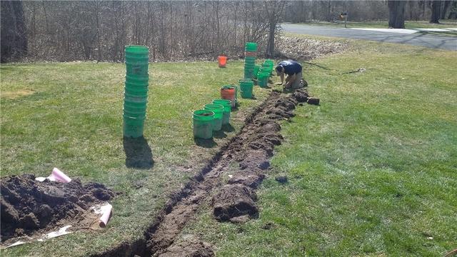 The sump pump discharge line is neatly buried and navigated away from the home so that water isn't consistently cycling back into the basement. The process is done in such a way as to cause little to no damage to the yard.