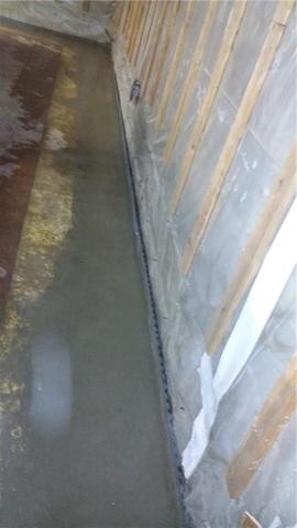 Concrete is replaced over top of the WaterGuard system. The drain does create a small gap along the base of the wall to capture any moisture that may flow down the wall from cracks or gaps that could develop. The drain also captures moisture where the walls and floor meet.