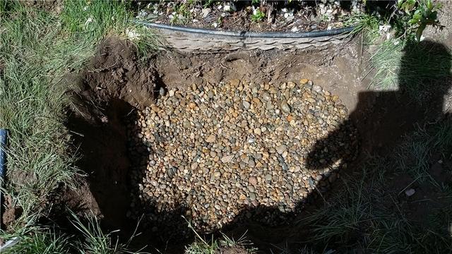 The outlet for the discharge will sit on top of drainage stone to help aid the water in leaching back into the soil away from the home.