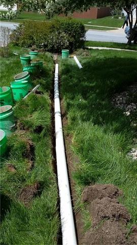 The path for the discharge is dug out with chunks of grass being kept neatly intact and dirt being placed in buckets so as to cause minimal damage to the lawn. The pvc is put in place and glued together.