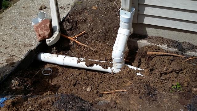 The discharge line passed right by a downspout which was safely tied in. The discharge then passes underneath the sidewalk and into the main portion of the yard and a safe distance away from the home so that any moisture doesn't cycle back into the basement.