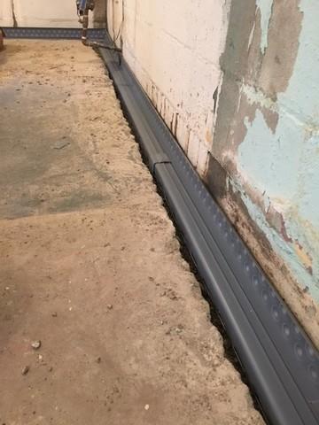 After digging up around the footing of the home we were able to install our patented drain tile system which will drive water away from the foundation and into a sump pump.