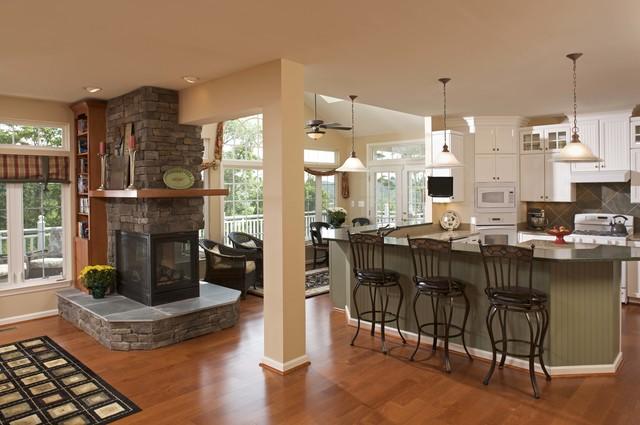 This fireplace makes the perfect divider between kitchen and living space while still being true to the open concept of the main floor. The wrap around mantle is another element that gives continuity and brings the spaces together.