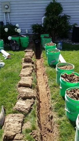 The LawnScape outlet (next photo) allows us to bury the discharge line, eliminating trip hazards and having to look at a big pipe every day. Here, the lawn is prepared by carefully removing sod to replace after the line is in place.