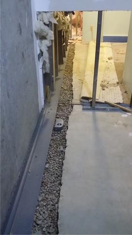 We pour drainage stone to help the WaterGuard collect and direct water without getting overwhelmed. Note the inspection port about halfway down this photo - that will help our service techs access the system for annual maintenance.