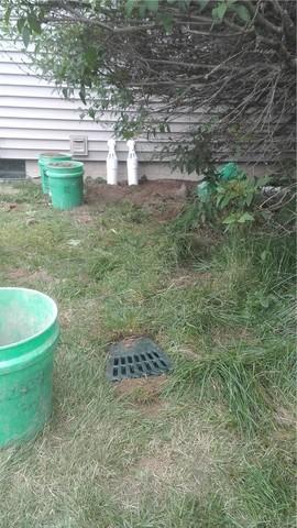 The Lawnscape outlet (foreground) allows us to bury the discharge line without risking it getting clogged by debris. This prevents trip hazards and landscaping nightmares, as well as eliminates the eyesore of the line.