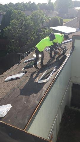 Applying shingles for the new roof.