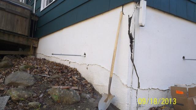 <p>Woodbridge CT block foundation with a major crack due to settlement at the garage corner of the house. Visible are 2 threaded rods for wall anchor plate installation.</p>