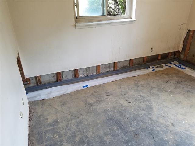 When the basement walls are finished (aka covered with drywall, paneling, etc), it's necessary to remove a small amount in order to access the seam of the wall and floor to remove a portion of the floor. We can't guarantee the height needed, as it varies between homes, but we work hard to minimize inconvenience.