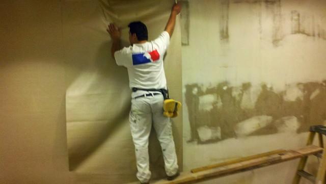 One of our wallpaper hangers are installing wallpaper on a 3 story stairwell inside the hotels main lobby.