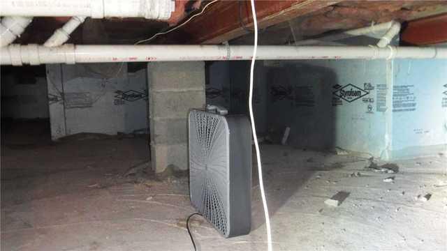 Fans in the center of the crawl space attempt to move the air around and keep the space dry.