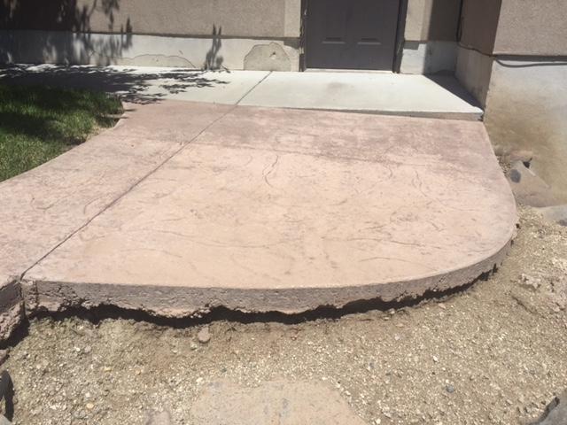 The soil has washed out from under this stamped concrete slab causing it to drop. We used our PolyLevel foam to lift it back to level.