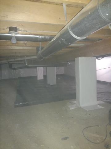 To begin the moisture barrier installation, we first begin installing dimple matting on the floor. This dimple matting facilitates the flow of water through the crawl space to the low spot, where a sump system can remove that water from the crawl space.