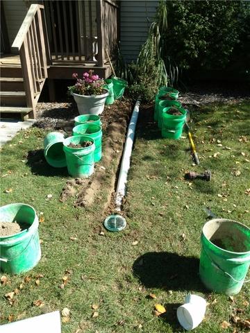 The discharge line for the sump system is buried in the yard. Any grass or soil removed is placed in buckets to prevent any unnecessary damage to the yard during the installation.