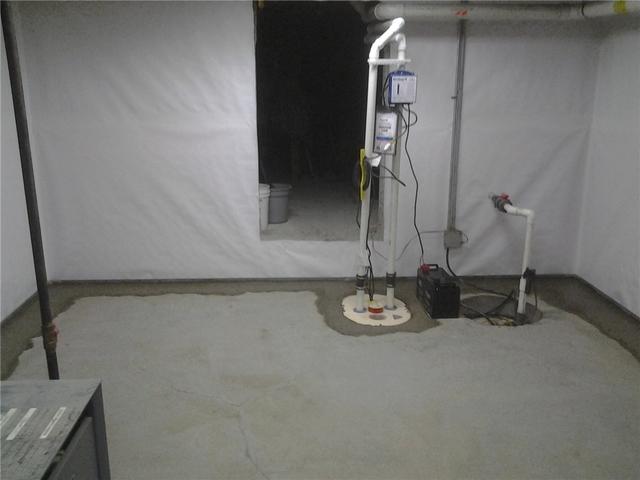 The TripleSafe Sump Pump System is seen here with a battery back up and discharge line that leads out of the home. The WaterGuard drains into the pit where the sump pump removes the water from the basement.