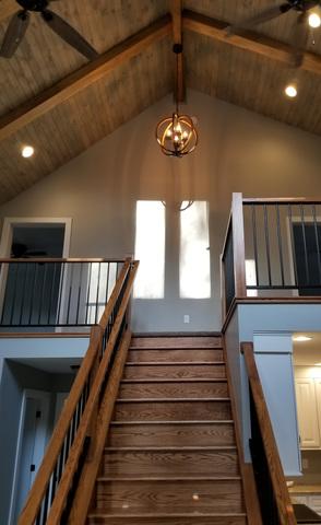 Bottom of stairs looking up, custom railings, exposed beams and ceiling.