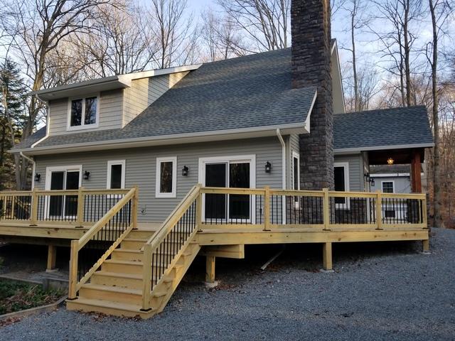 View from side of home. Wood deck (pre-stain) custom metal railing inserts.