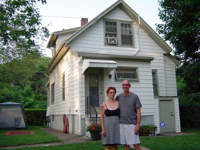 Happy homeowners in front of their freshly painted home