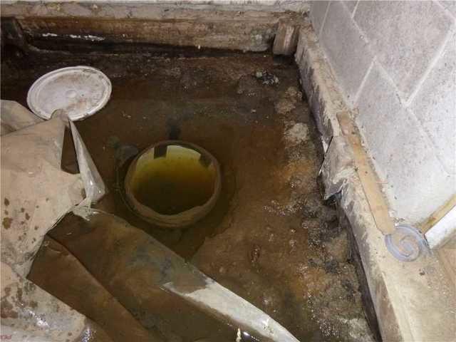 This looks to be a sump pump that isn't doing its job at all. Open sump holes are useless because they allow the water to evaporate back into the air and eventually up into the house.