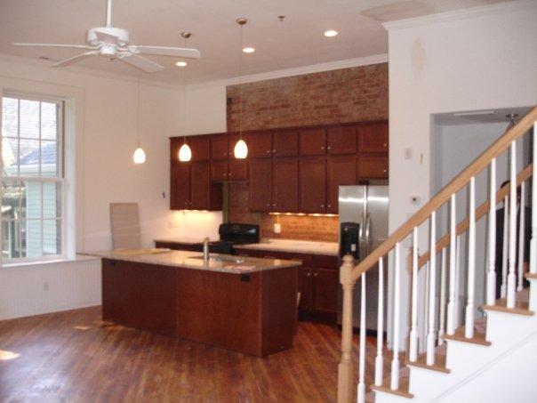 <p>Painted kitchen with crown moulding, stair railing, and brick work.</p>