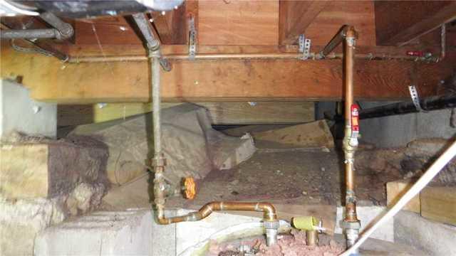 Here, in one of the "tall" areas of the crawl space, you can see the extent of the damage. Rust on pipes and warping beams point to longstanding ambient moisture.