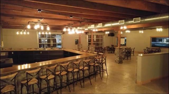 Here you see the rustic seating area with lighting with ceiling fixtures that resemble pipe fittings in theme with the pipes that are used for their stills.