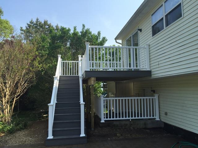 A view of the whole deck, stairway up, and the railing outside the basement.