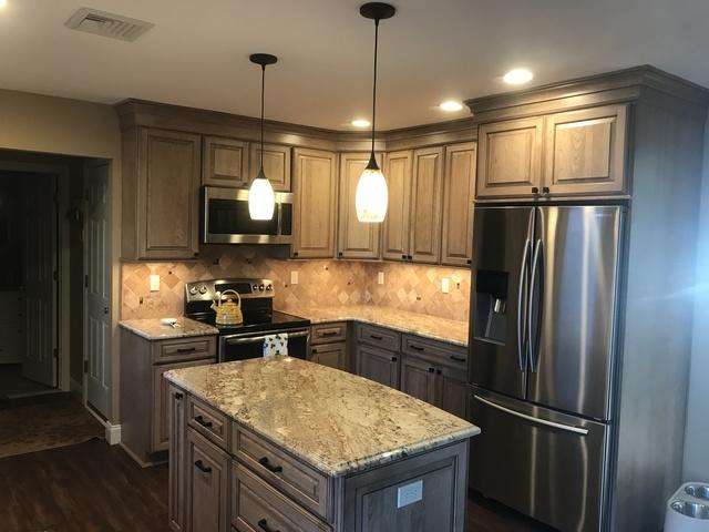 View of the finished kitchen, including granite counter tops, light fixtures, cabinets, and stainless steel kitchen appliances.